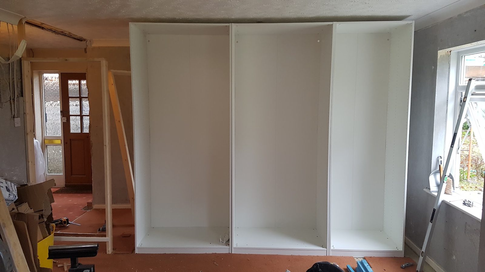 Fitted wardrobe carcasses going in along a bedroom wall