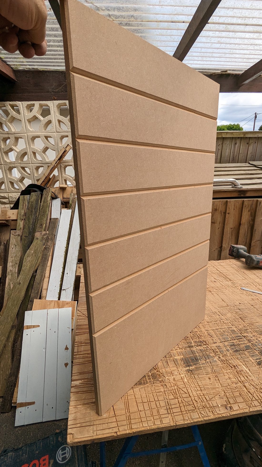 Grooved panel being prepared on the workbench outdoors